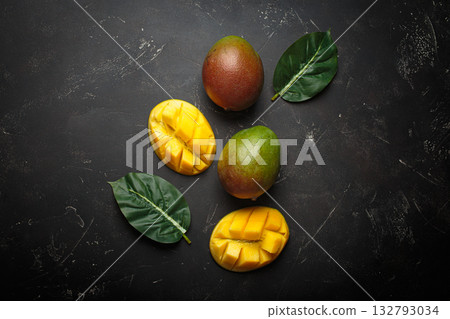 Ripe tropical sliced whole mangoes leaves dark background healthy exotic fruit 132793034