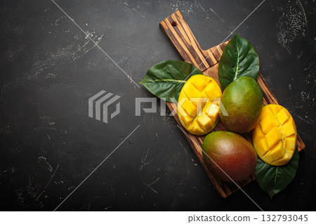 Fresh mango exotic fruit sliced whole cutting board dark background preparing copy space Fresh mango exotic fruit sliced whole cutting board dark background preparing copy space 132793045