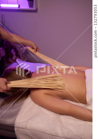 Experience relaxation and muscle relief with a spa treatment using bamboo sticks for rejuvenation 132793053