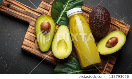 Avocado smoothie fresh fruit halves dark background cutting board healthy drink diet nutrition Avocado smoothie fresh fruit halves dark background cutting board healthy drink diet nutrition 132793056