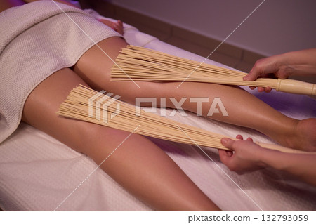 Experience relaxation and muscle relief with a spa treatment using bamboo sticks for rejuvenation Experience relaxation and muscle relief with a spa treatment using bamboo sticks for rejuvenation 132793059