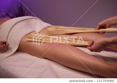 Experience relaxation and muscle relief with a spa treatment using bamboo sticks for rejuvenation Experience relaxation and muscle relief with a spa treatment using bamboo sticks for rejuvenation 132793060