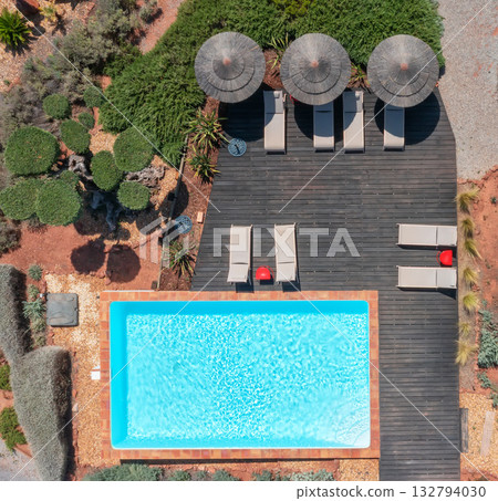 Chic outdoor leisure scene, Stylish sunlit terrace with pools and umbrellas, Luxurious Mediterraneaninspired pool area with relaxing loungers and decorative plants 132794030