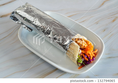 Delicious Rolo Durum kebab portable meal, Warm chicken wrap with slaw, Streetstyle chicken roll with crunchy vegetables, Foilwrapped seasoned chicken with crisp slaw in tortilla Delicious Rolo Durum kebab portable meal, Warm chicken wrap with slaw, Streetstyle chicken roll with crunchy vegetables, Foilwrapped seasoned chicken with crisp slaw in tortilla 132794065