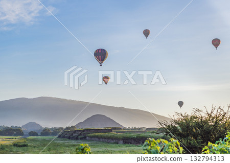 Colorful hot air balloons floating over Teotihuacan in Mexico, creating a breathtaking view of the ancient pyramids. Tourism, adventure, and cultural heritage concept Colorful hot air balloons floating over Teotihuacan in Mexico, creating a breathtaking view of the ancient pyramids. Tourism, adventure, and cultural heritage concept 132794313