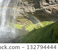 This is a view of the straight waterfall and miraculous rainbow seen from the right front of the basin of Seljalandsfoss, a waterfall in southern Iceland. 132794444