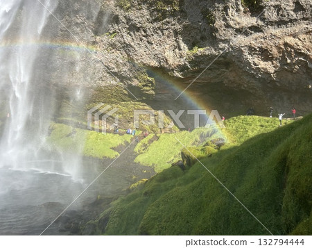 This is a view of the straight waterfall and miraculous rainbow seen from the right front of the basin of Seljalandsfoss, a waterfall in southern Iceland. This is a view of the straight waterfall and miraculous rainbow seen from the right front of the basin of Seljalandsfoss, a waterfall in southern Iceland. 132794444