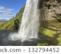 This is a straight waterfall and a beautiful miraculous rainbow seen from the right side of the basin of Seljalandsfoss, a waterfall in southern Iceland. 132794452
