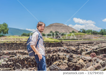 Male tourist posing in front of the pyramids of Teotihuacan in Mexico, enjoying sightseeing, cultural heritage, and travel adventure 132794583