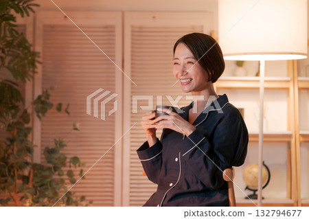 Woman in pajamas drinking a hot drink in her room at night 132794677