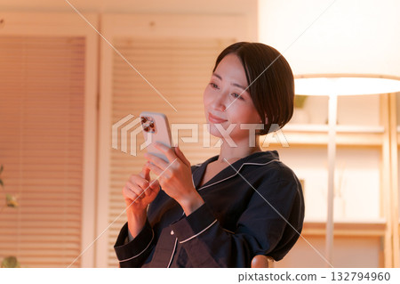 年輕女子在晚上看智能手機 132794960