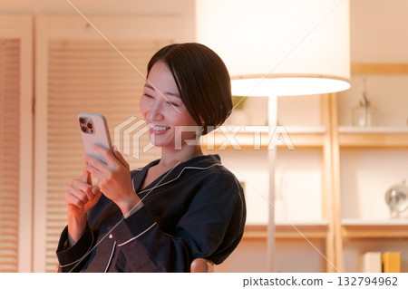 年輕女子在晚上看智能手機 132794962