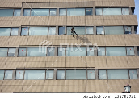 Workers cleaning windows in a high-rise building 132795031