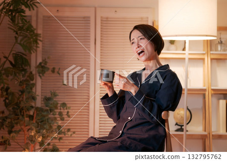 一位女士晚上興奮地看著電視 132795762