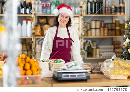 Woman seller at counter in decorated grocery store Woman seller at counter in decorated grocery store 132795878