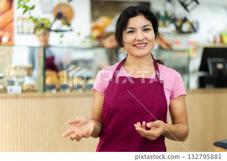 Polite waitress welcomes clients in cafeteria Polite waitress welcomes clients in cafeteria 132795881