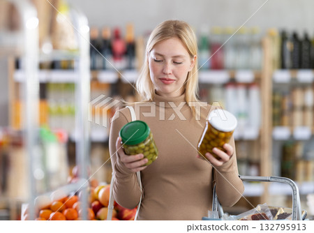Young woman choosing olives in grocery store Young woman choosing olives in grocery store 132795913