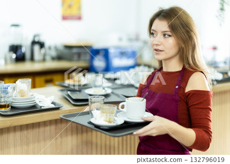Cafe waitress carries a tray with dirty dishes closeup 132796019