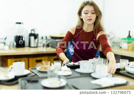 Cafe waitress carries a tray with dirty dishes closeup Cafe waitress carries a tray with dirty dishes closeup 132796075