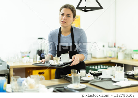 Cafe waitress carries a tray with dirty dishes closeup Cafe waitress carries a tray with dirty dishes closeup 132796102