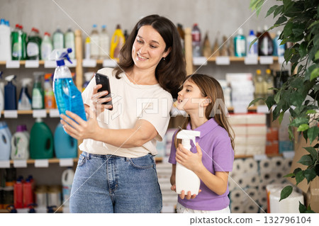 Mom and daughter scanning the barcode on the spray package 132796104