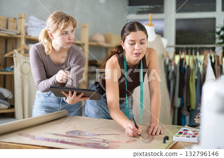 Female tailors working together in workshop with tablet and paper 132796146