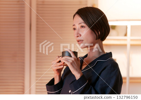 A woman in pajamas relaxing in her room watching TV at night 132796150