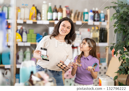Woman with child family selects and studies label makeup cosmetic agent 132796222