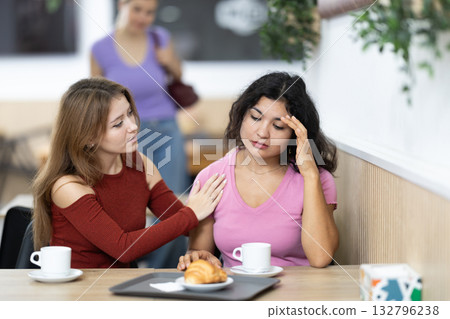Young woman comforts her girlfriend in cafe Young woman comforts her girlfriend in cafe 132796238