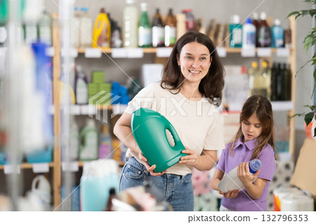 Woman with daughter choosing detergent in store 132796353