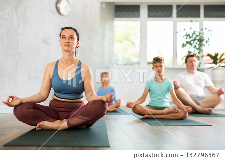 Woman performs lotus pose, folding fingers in mudra of knowledge Woman performs lotus pose, folding fingers in mudra of knowledge 132796367