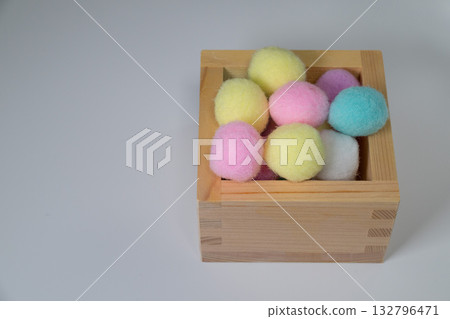 一個木盒，裡面裝滿了顏色柔和的毛線球。 132796471