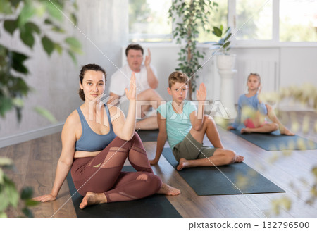 Family with two children doing yoga in studio 132796500