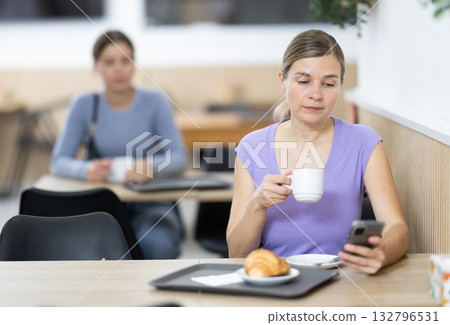 Adult woman with phone in cafe 132796531