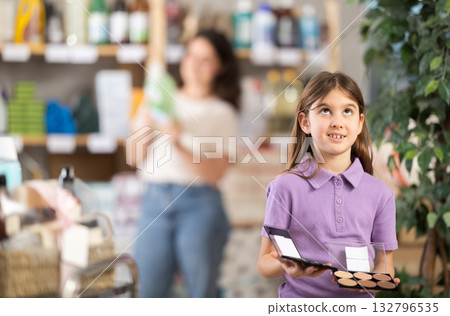 Girl choosing cosmetics against the background of her mother 132796535