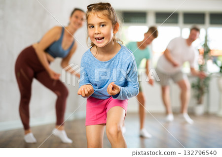 At home child learns to perform boogie-woogie figures with family 132796540