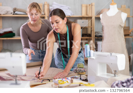 Two Female Tailors Drawing on Paper 132796564