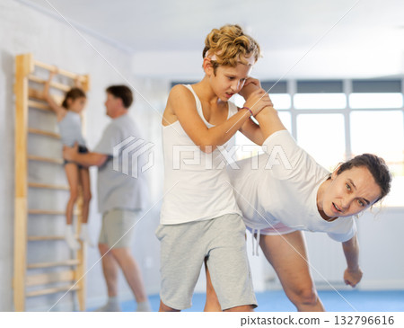 Boy and his mother learn how to do painful techniques during self defense lessons Boy and his mother learn how to do painful techniques during self defense lessons 132796616