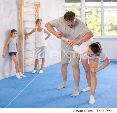 Parents and children during training and self-defense workout. 132796628