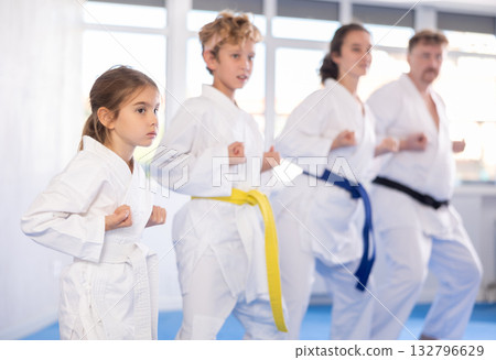 Family with children in kimono trying new martial moves at karate class 132796629