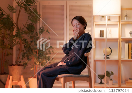 A woman relaxing in a chair at night A woman relaxing in a chair at night 132797024