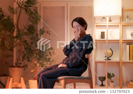 A woman relaxing in a chair at night 132797025