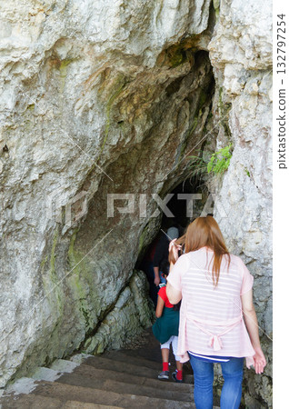 A woman cautiously descends the stairs into the cave A woman cautiously descends the stairs into the cave 132797254