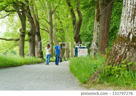 公園裡,一男一女並肩走在碎石路上,這是他們的背影。 公園裡,一男一女並肩走在碎石路上,這是他們的背影。 132797276