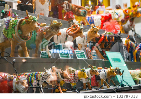 A display of cow ornaments behind glass found in the city at night 132797318
