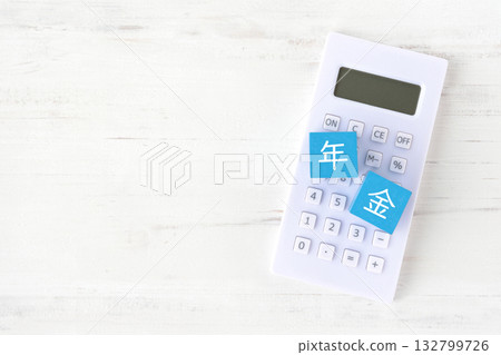 寫著「退休金」字樣的方塊和一個計算器——退休金福利模擬圖 寫著「退休金」字樣的方塊和一個計算器——退休金福利模擬圖 132799726