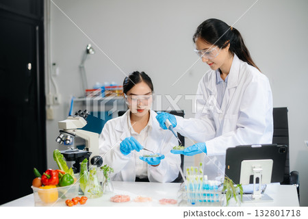 Food scientists in lab coats, testing samples, and analyzing food safety and quality 132801718