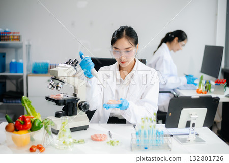 Food scientists in lab coats, testing samples, and analyzing food safety and quality Food scientists in lab coats, testing samples, and analyzing food safety and quality 132801726