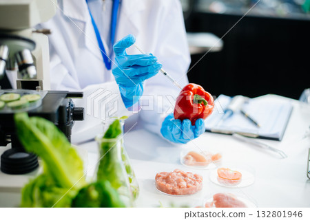 Two Asian scientists in a lab conducting food research using a microscope and lab equipment, showcasing innovation in food science 132801946