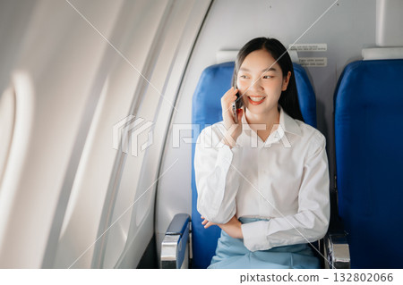Attractive Asian female passenger of airplane sitting in comfortable seat while working laptop and tablet with mock up area using wireless connection. Attractive Asian female passenger of airplane sitting in comfortable seat while working laptop and tablet with mock up area using wireless connection. 132802066